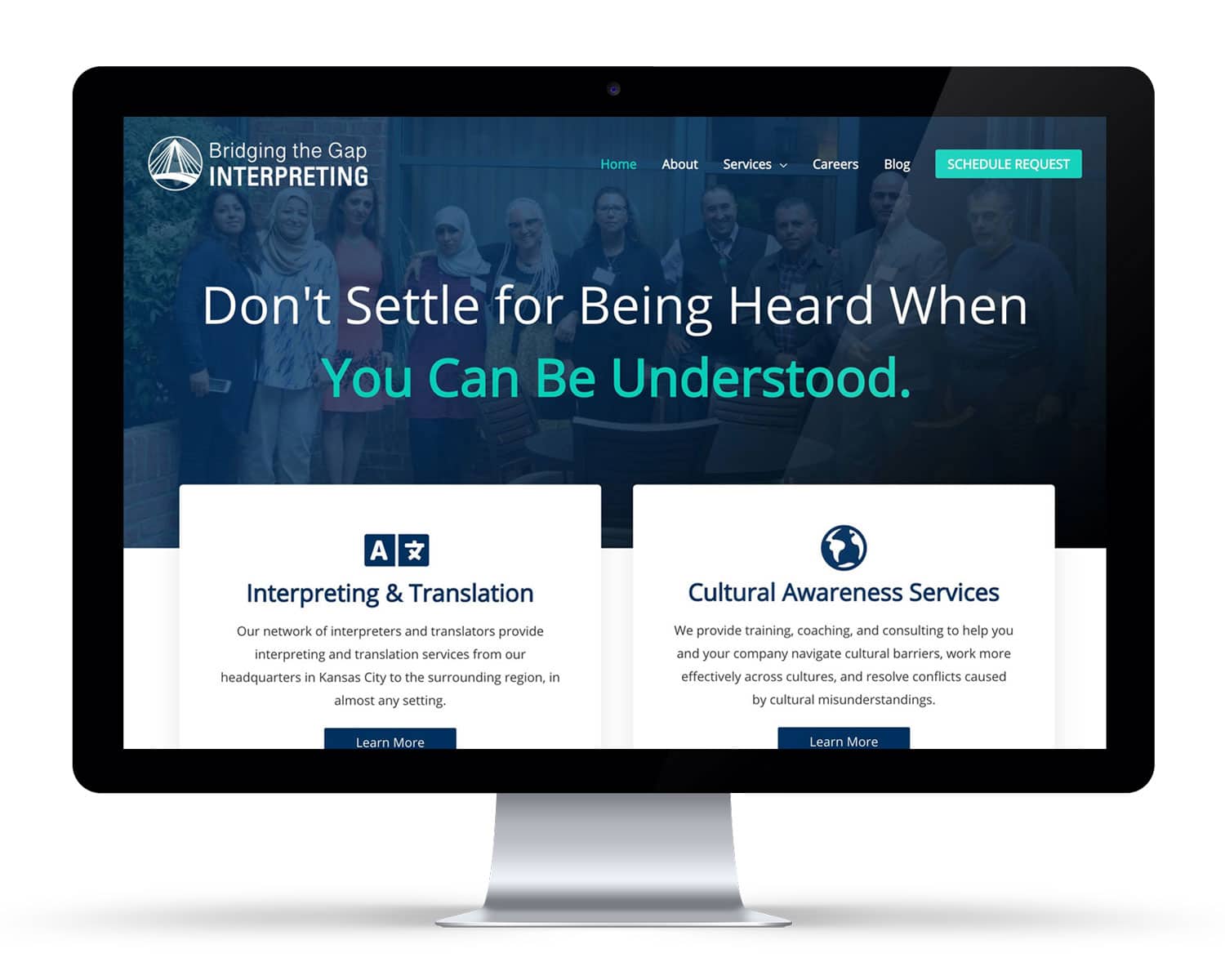 cp-web-iMac-mockups-btgi-after A computer monitor displays the homepage of Bridging the Gap Interpreting, featuring service options for interpreting, translation, and cultural awareness.