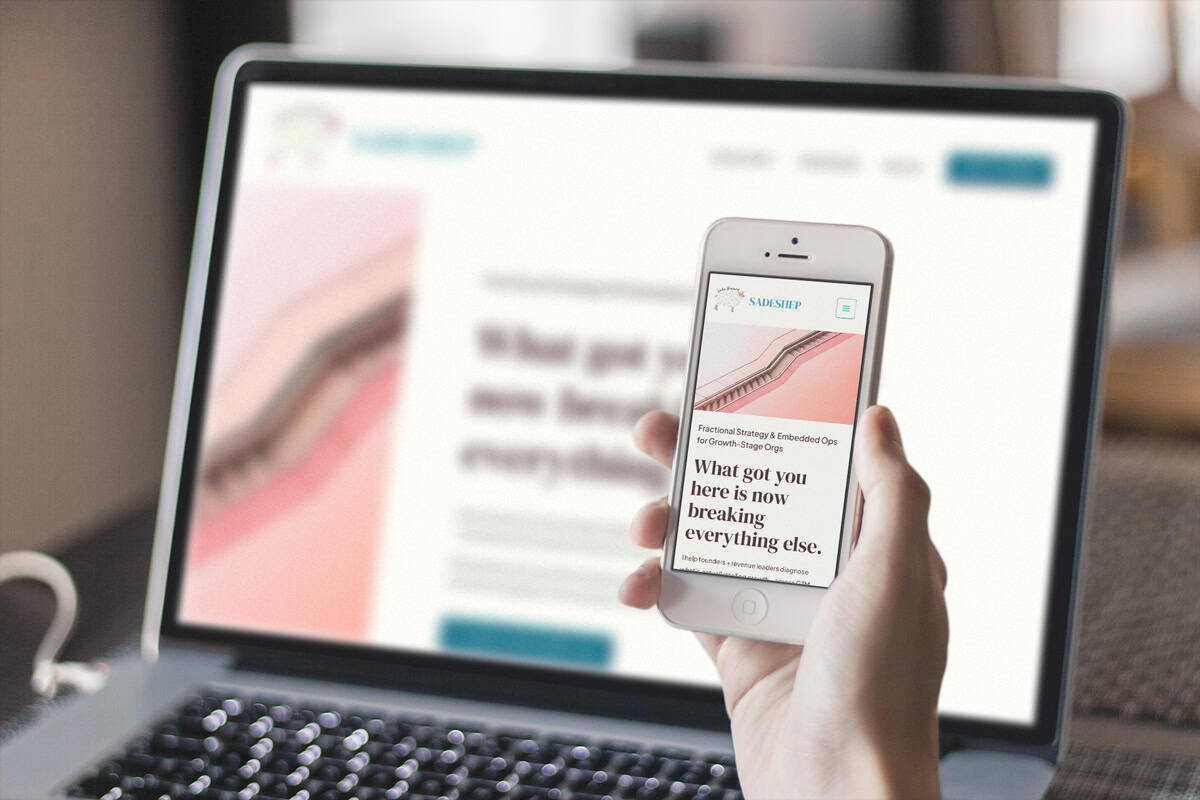 project-responsive-iphone-macbook-sadeshep2 A person holds a smartphone displaying a website with the headline, "What got you here is now breaking everything else," in front of a blurred laptop showing the same site.