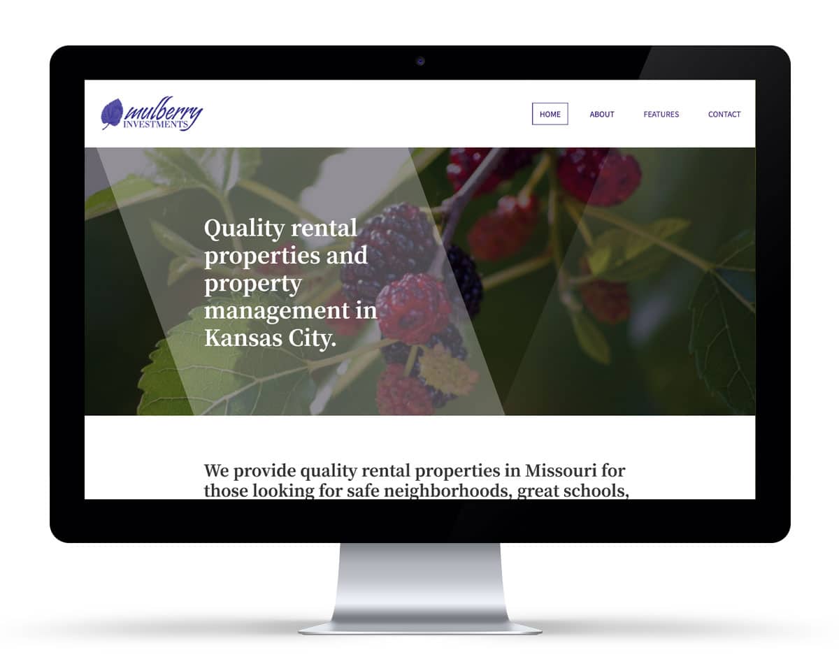 A computer monitor displays a website for Mulberry Investments, promoting rental properties and property management in Kansas City, with a background image of mulberries.